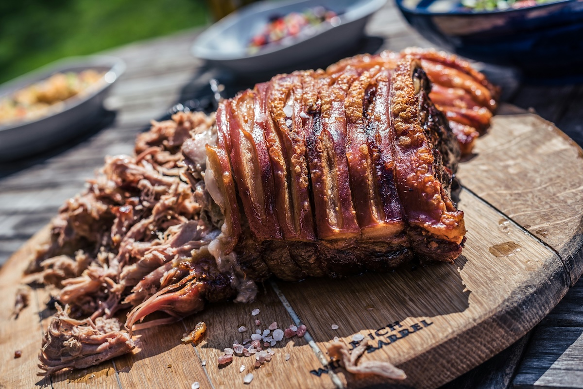 Un costillar de cerdo ahumado y jugoso cortado sobre una tabla de madera.⁠